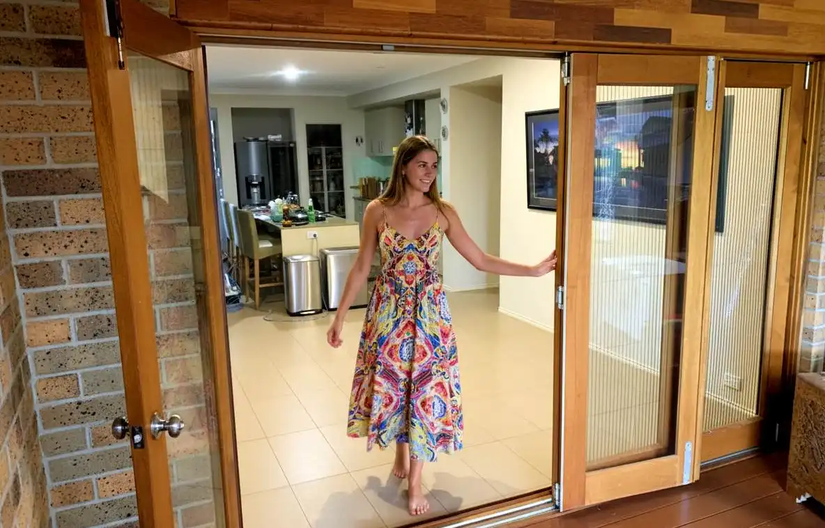 lady in summer dress walks through french door screens